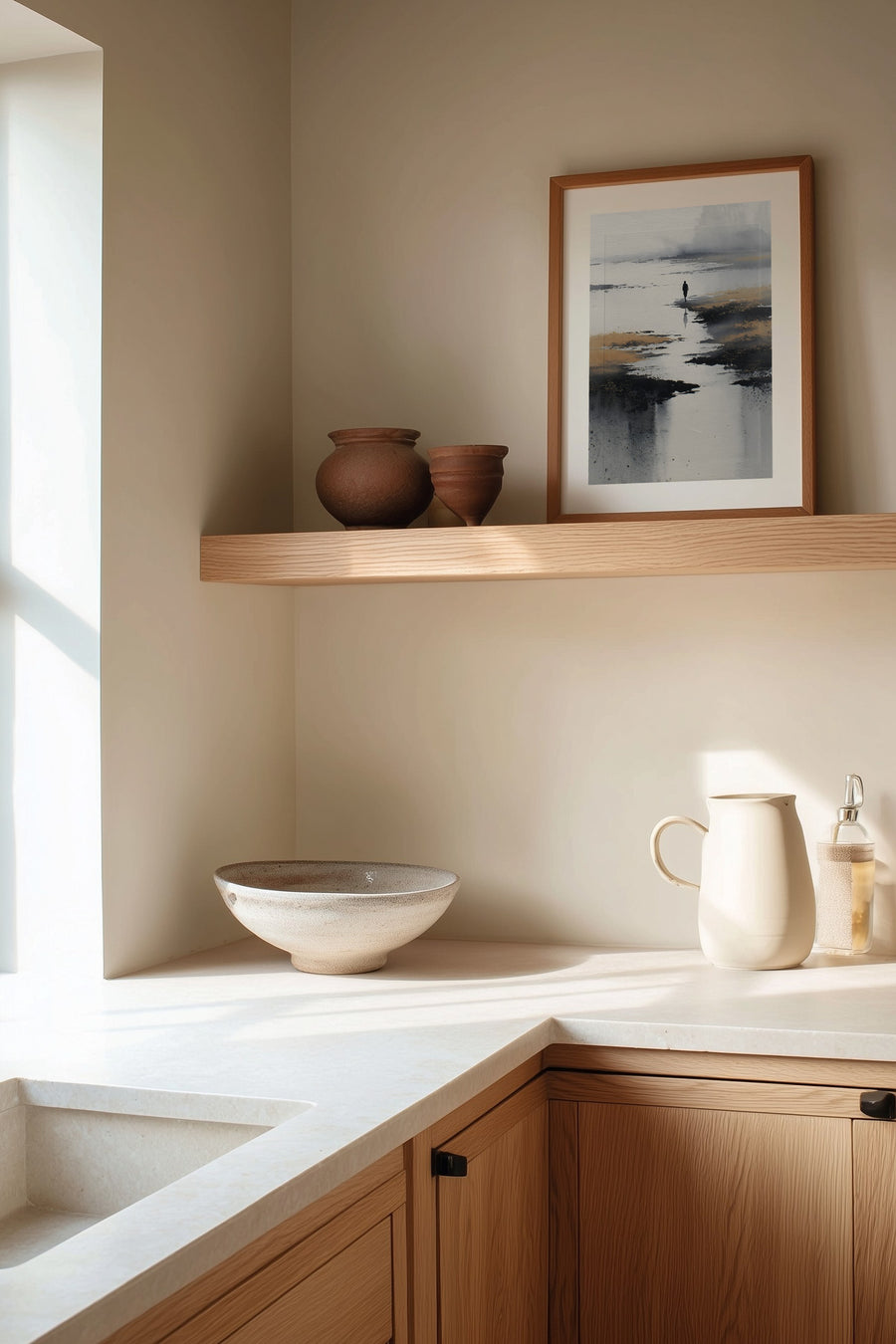 Low Tide sumi-e print framed on the wall above a wood shelf in a warm ivory kitchen corner