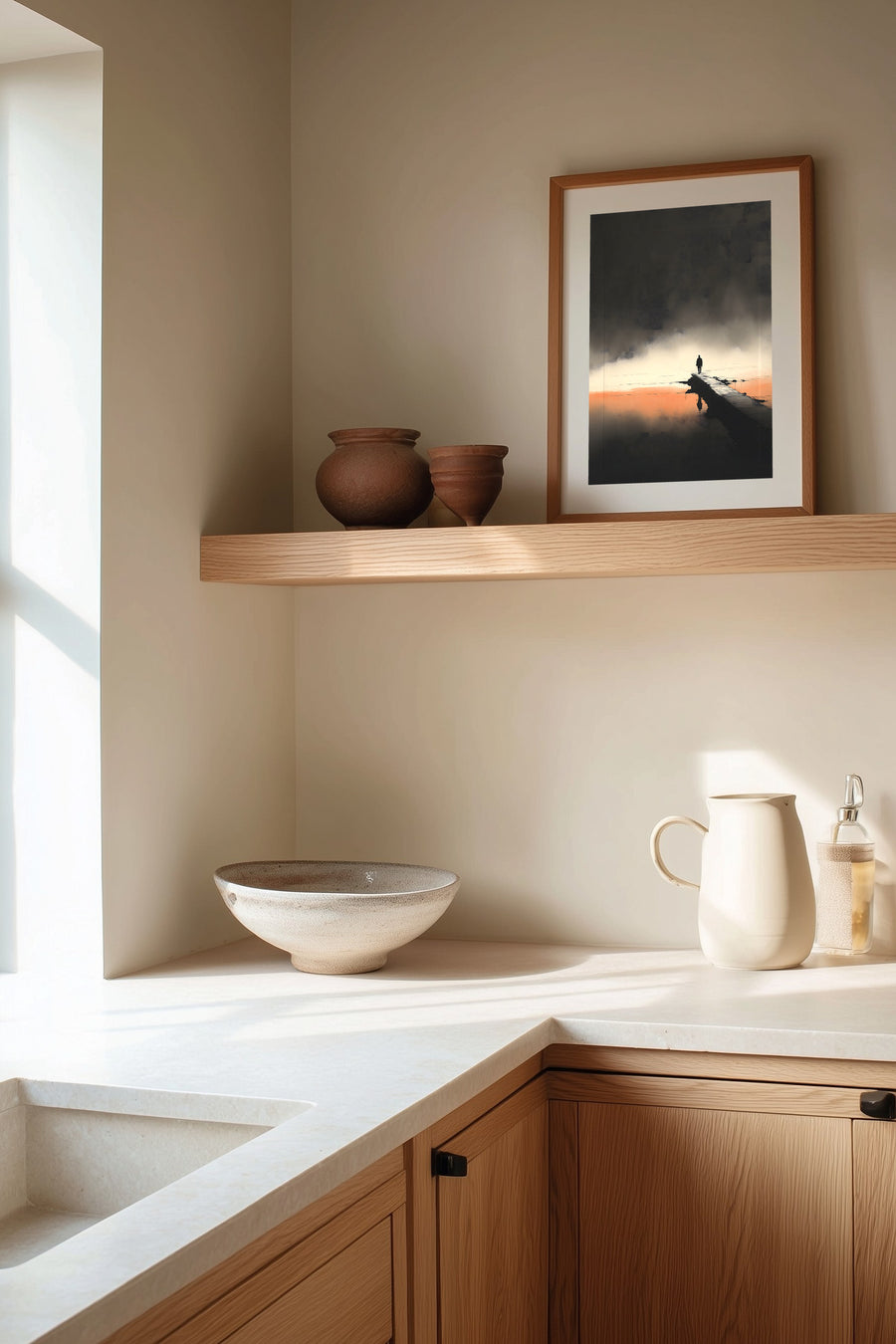 The Last Pier sumi-e print framed on the wall above a wood shelf in a warm ivory kitchen corner