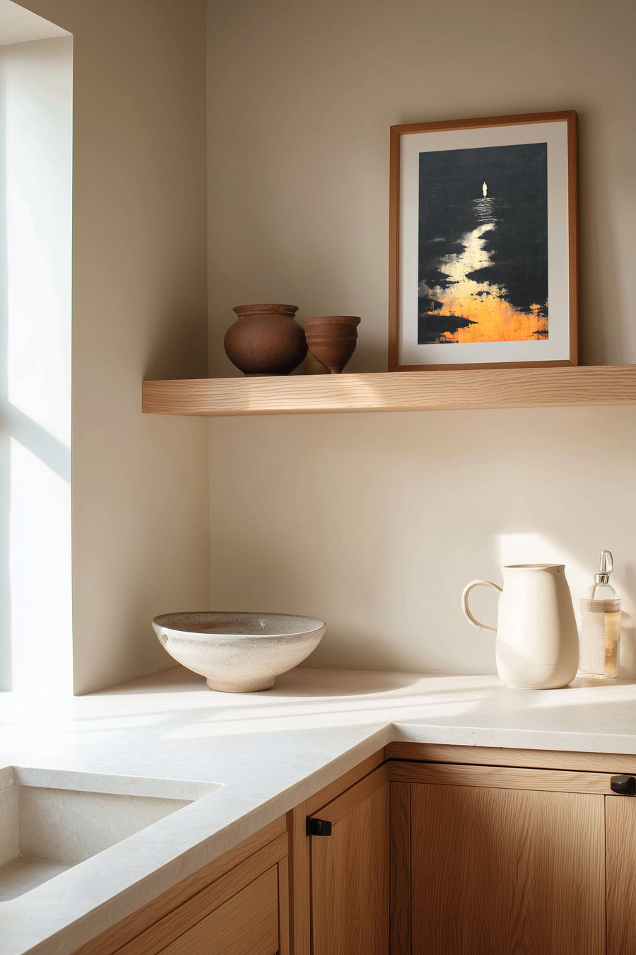 The Pale Wanderer sumi-e print framed on the wall above a wood shelf in a warm ivory kitchen corner