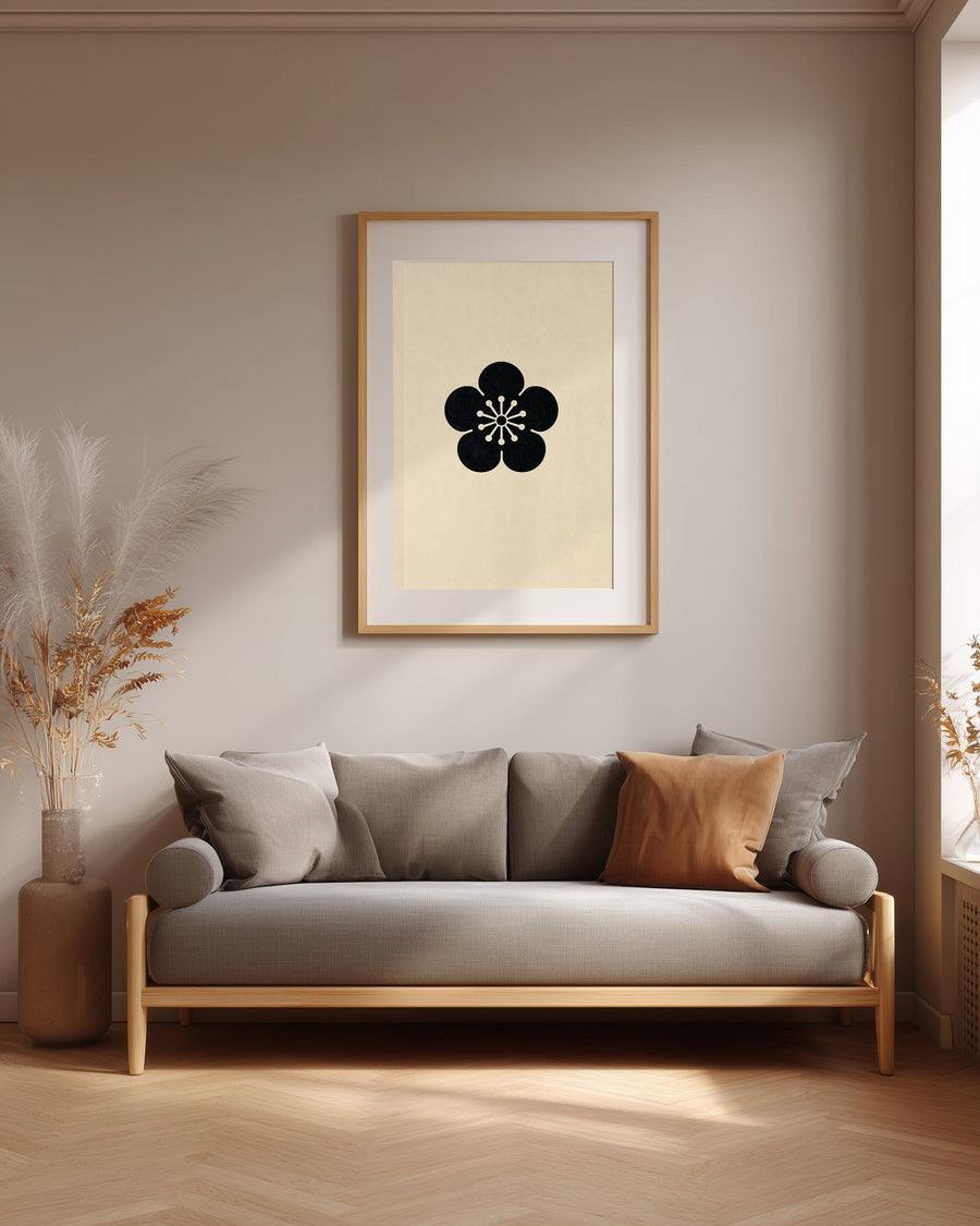 Ume plum blossom kamon print in black on cream, framed above a grey sofa in a japandi living room
