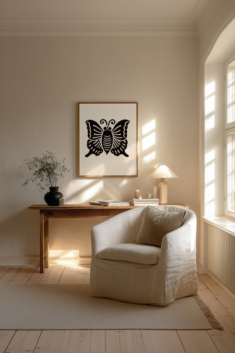 Agehachō butterfly kamon print in black on cream, framed above a wooden desk beside a cream armchair in a sunlit living room
