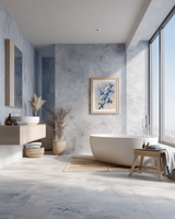 Blue cherry blossom print framed on a blue stone wall in a serene spa-style bathroom with a freestanding tub and natural textures.