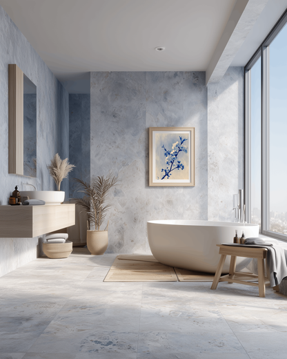 Blue cherry blossom print framed on a blue stone wall in a serene spa-style bathroom with a freestanding tub and natural textures.