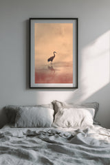 Crane at Dawn print in a black frame above a bed with grey linen bedding