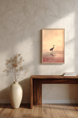 Crane at Dawn print framed above a dark wood console and a cream vase on a plaster wall