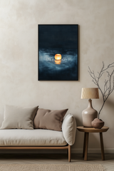 Sumi-e style indigo ink print of a single glowing paper lantern on dark water, black frame above a pale linen sofa with a wooden side table and ceramic lamp, Yugen Print