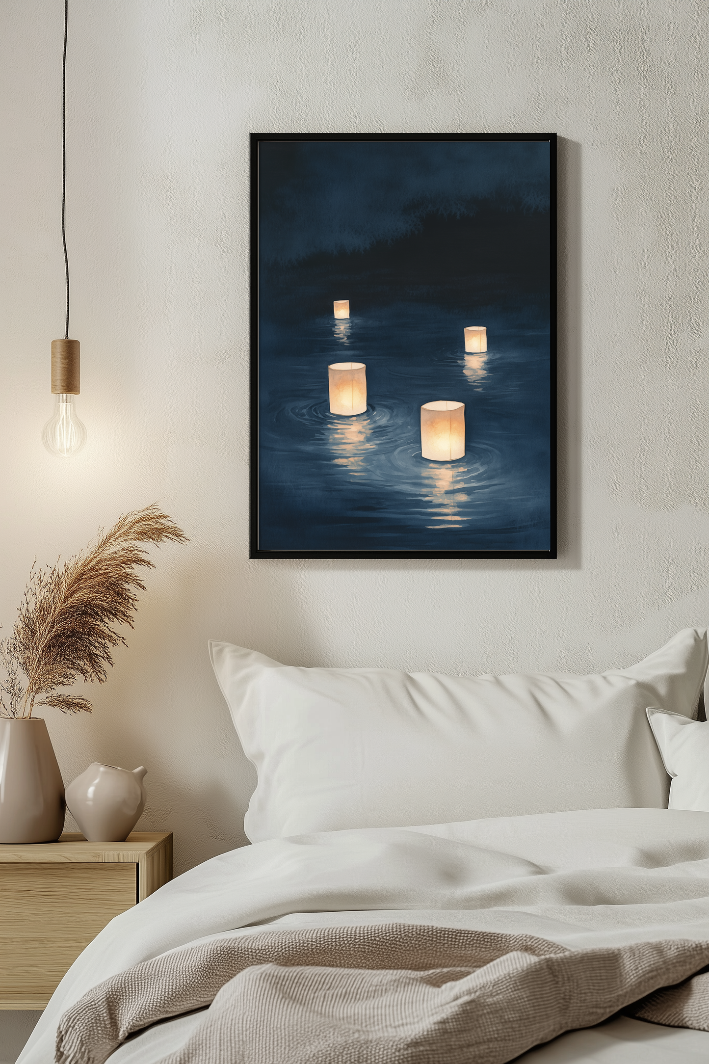 Sumi-e style indigo ink print of floating paper lanterns at night, black frame above white bedding beside a warm pendant light in a serene evening bedroom, Yugen Print
