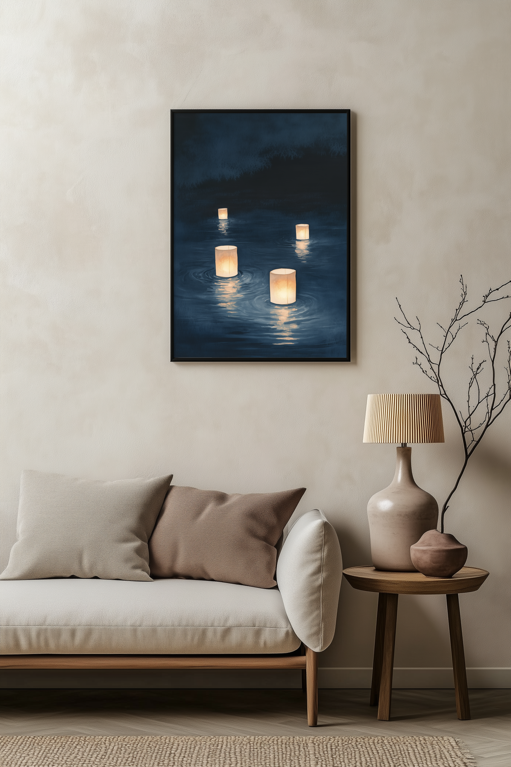 Sumi-e style indigo ink print of floating paper lanterns glowing on dark water, black frame above a pale linen sofa with a wooden side table and ceramic lamp, Yugen Print