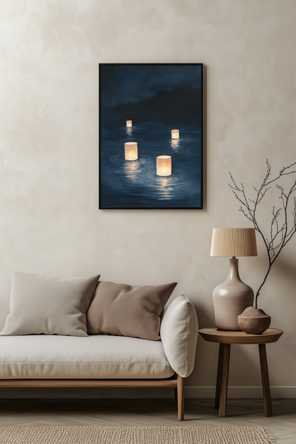 Sumi-e style indigo ink print of floating paper lanterns glowing on dark water, black frame above a pale linen sofa with a wooden side table and ceramic lamp, Yugen Print