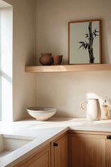 Golden Seam Bamboo print shown framed in a kitchen corner, a dark ink bamboo stalk with gold kintsugi seams along its joints on a parchment ground