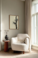 Golden Seam Bamboo print shown framed in a reading corner, a dark ink bamboo stalk with gold kintsugi seams along its joints on a parchment ground