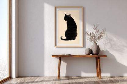 A framed art print of a black cat silhouette on a cream background, displayed on a white wall above a wooden console table with decorative vases in a bright, modern room.