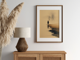 Sumi-e style ink wash print of a small figure standing at the misty water's edge, in an oak frame above a cane sideboard with a rattan lamp and pampas, Yugen Print