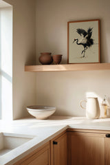 Kintsugi Dancing Crane print shown framed in a kitchen corner, a red-crowned crane lifts a foot and arches its wings, ink splashing and gold pooling at its feet