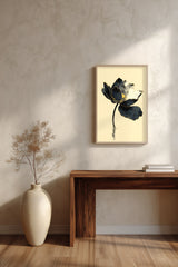 Kintsugi Lotus print shown framed in a room above a console table, a dark ink lotus flower with gold-edged petals on a curved stem above rippling water