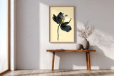 Kintsugi Lotus print shown framed in an entryway, a dark ink lotus flower with gold-edged petals on a curved stem above rippling water