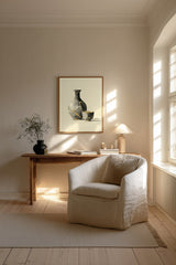 Kintsugi Sake Set print shown framed in a Scandi living room, a grey sake flask and small cup mended with gold kintsugi seams on a cream ground