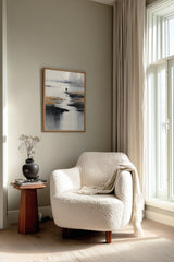Low Tide sumi-e print framed beside a white armchair and side table in a reading corner by the window