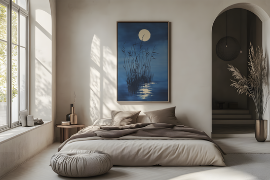Sumi-e style indigo ink print of tall reeds against a full moon reflected on still water, oak frame above a linen bed in a bright airy Japandi bedroom, Yugen Print