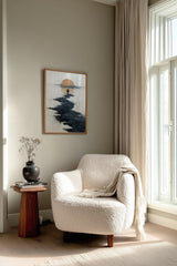 Path to the Setting Sun sumi-e print framed beside a white armchair and side table in a reading corner by the window
