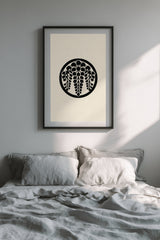 Sagari-fuji wisteria kamon print in black on cream, framed above the bed in a calm bedroom with grey linen bedding
