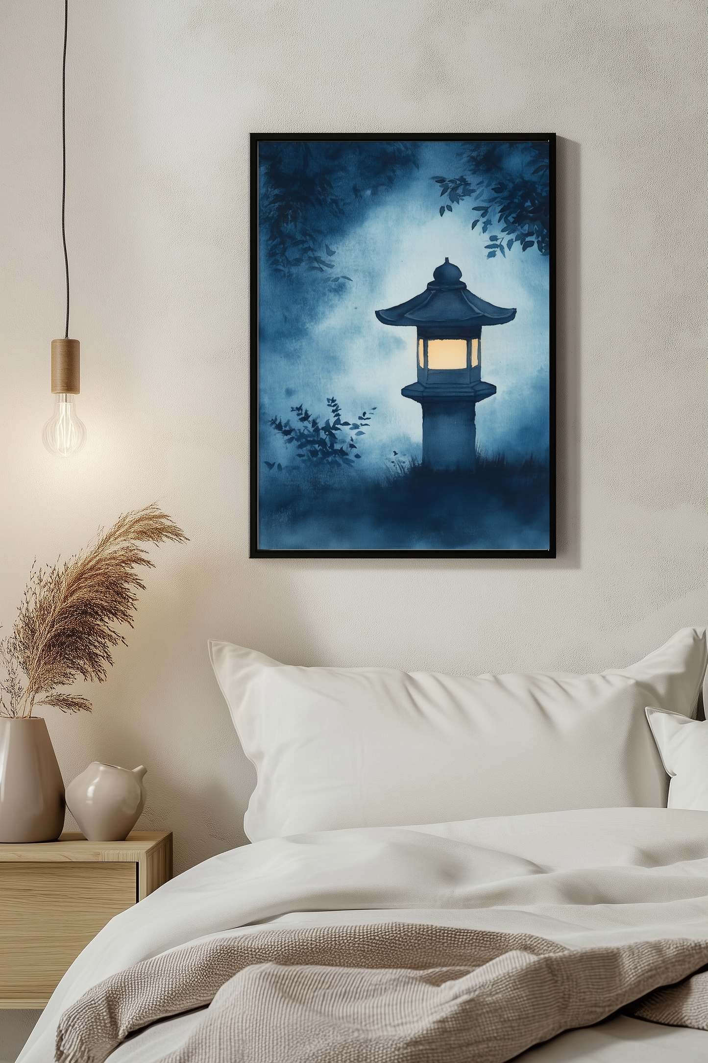 Sumi-e style indigo ink print of a glowing Japanese stone lantern at night, black frame above white bedding beside a warm pendant light in a serene evening bedroom, Yugen Print