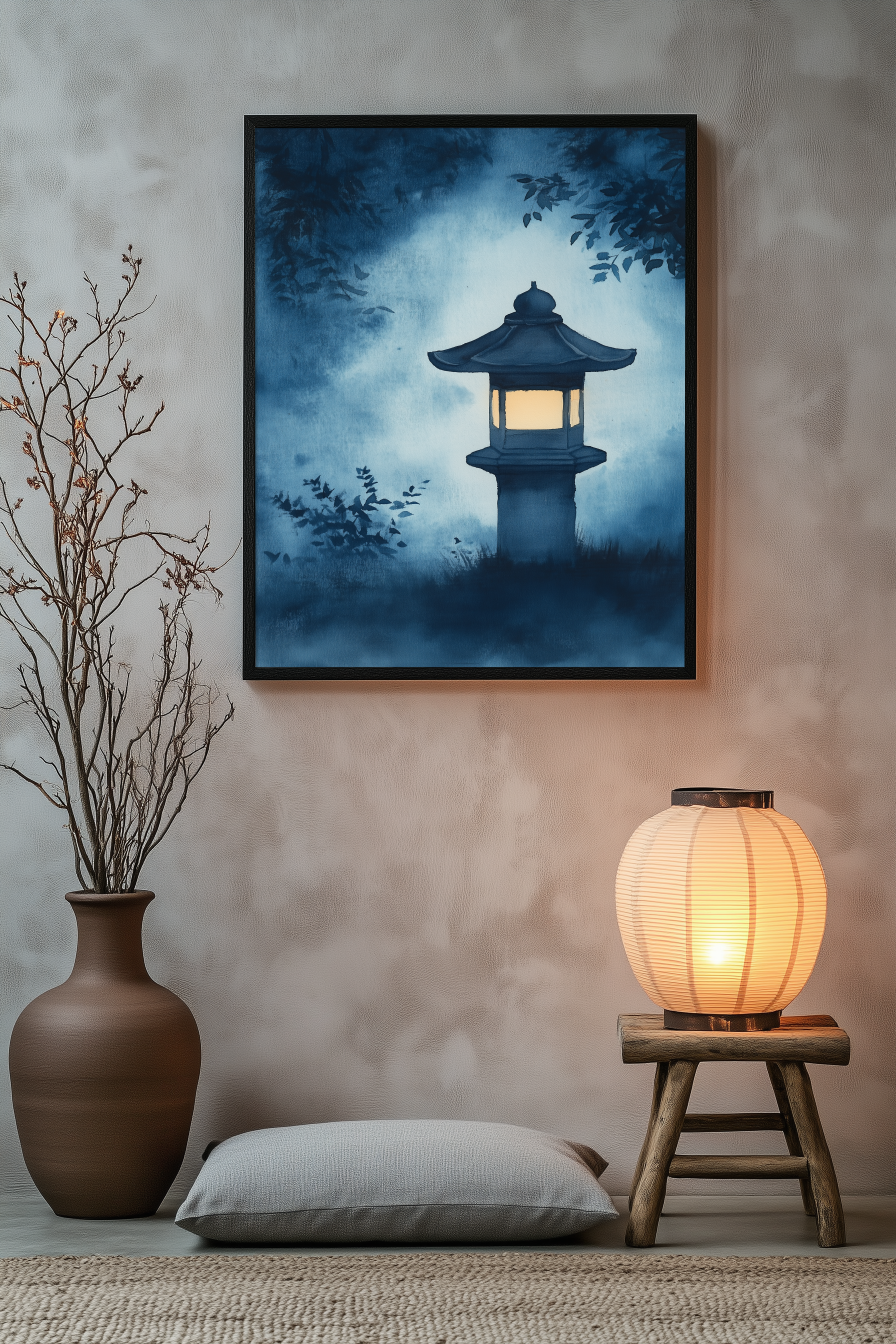 Sumi-e style indigo ink print of a glowing stone lantern in a misty garden, black frame above a floor cushion beside a glowing paper lantern on a wooden stool, Yugen Print