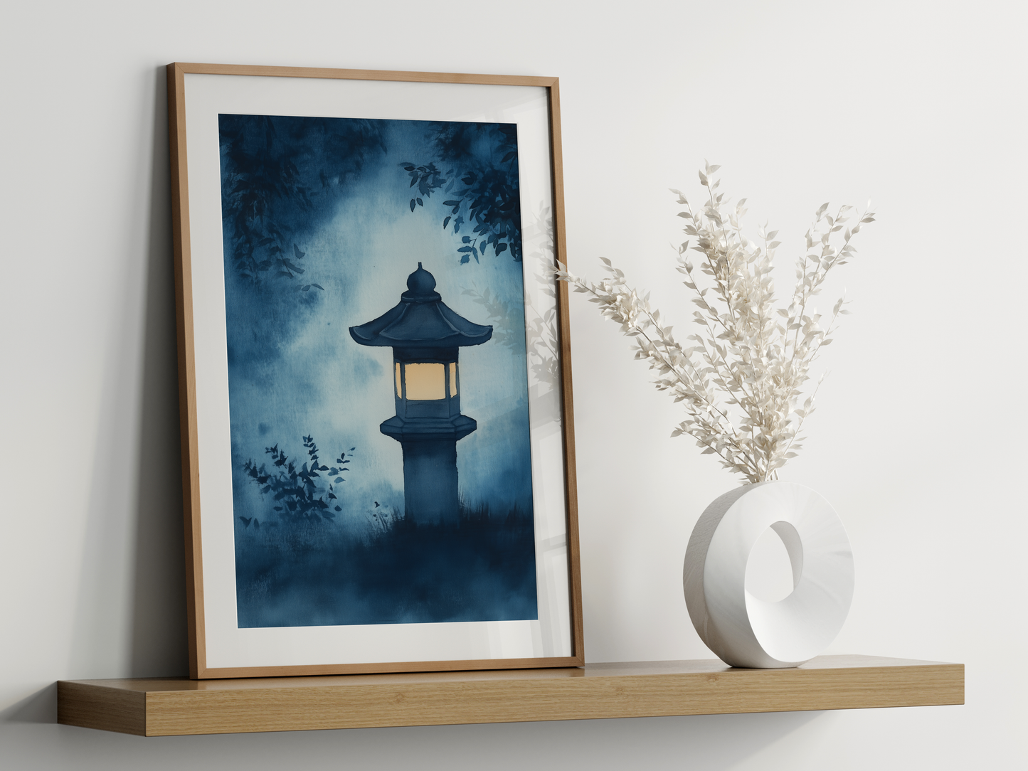 Sumi-e style indigo ink print of a glowing stone lantern in a misty garden, oak frame leaning on a floating wood shelf beside a white ceramic vase, Yugen Print