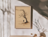 Sumi-e style ink print of a small lone figure beneath a windswept bare tree, framed in light wood on an entryway console with a dried branch and ceramic bowls, Yugen Print