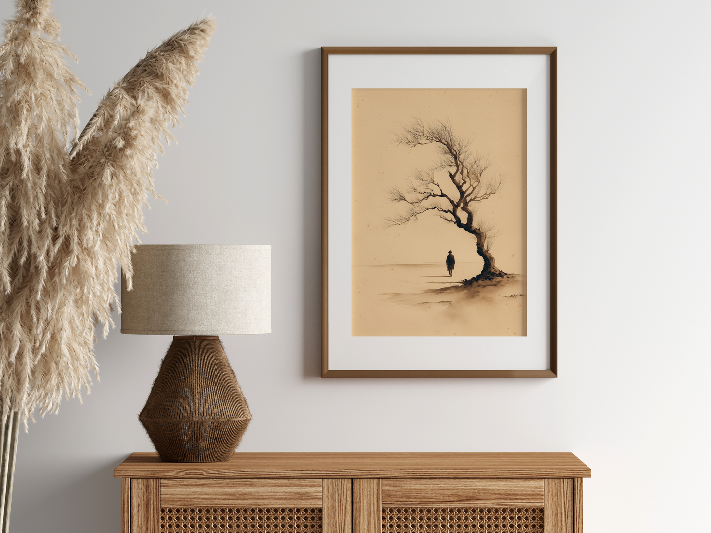 Sumi-e style ink print of a small figure under an old windswept tree, in an oak frame above a cane sideboard with a rattan lamp and pampas, Yugen Print