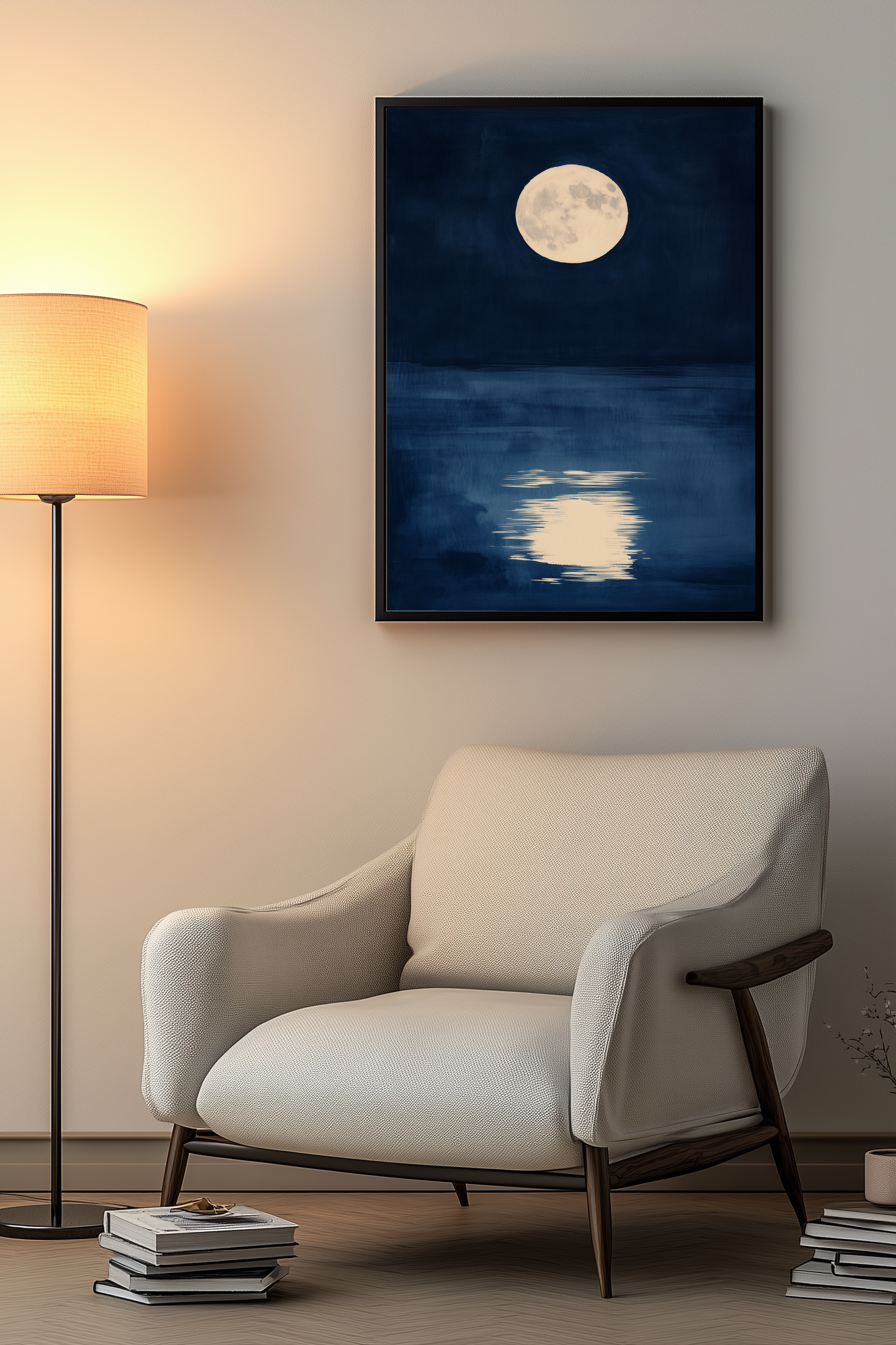 Sumi-e style indigo ink print of a full moon reflected on still water, black frame above a cream armchair beside a warm floor lamp in a cosy reading nook, Yugen Print