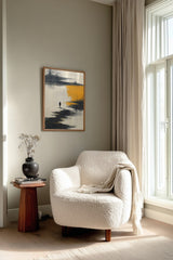 The Amber Shore sumi-e print framed beside a white armchair and side table in a reading corner by the window