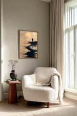 The Ronin's Moon sumi-e print framed beside a white armchair and side table in a reading corner by the window