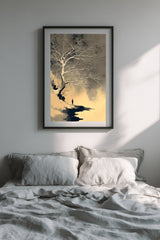 The White Tree sumi-e print in a black frame above a bed with grey linen bedding