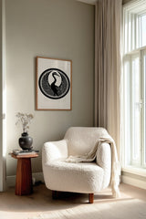 Tsuru crane kamon print in black on cream, framed above a cream reading chair by a sunlit window