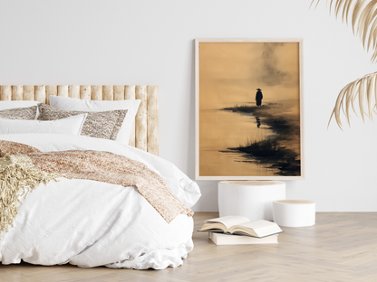 Sumi-e style ink print of a solitary figure on a misty shoreline with a reflection in the water, framed in light wood in a neutral bedroom above stacked books, Yugen Print
