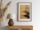 Sumi-e style ink print of a small figure on a misty shoreline, in an oak frame above a cane sideboard with a rattan lamp and pampas, Yugen Print
